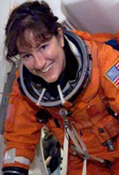 Laurel Clark in an orange spacesuit. She is a young woman with brown hair.